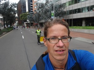 im vordergrund: ciclovía-teilnehmer mit migrationshintergrund - im hintergrund: ordnungskraft